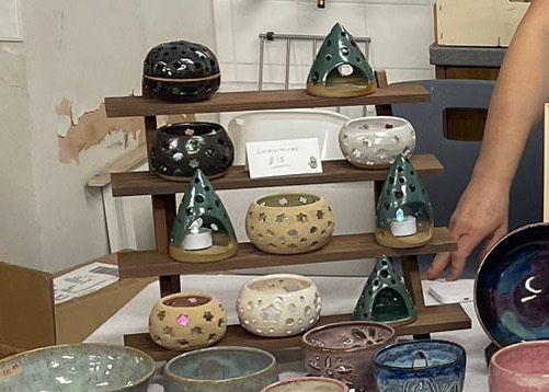 Tiered shelf of stoneware tealight lanterns and little tree-shaped candle holders, priced at £15