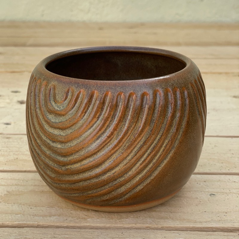 Amber-brown vessel carved with sweeping arches