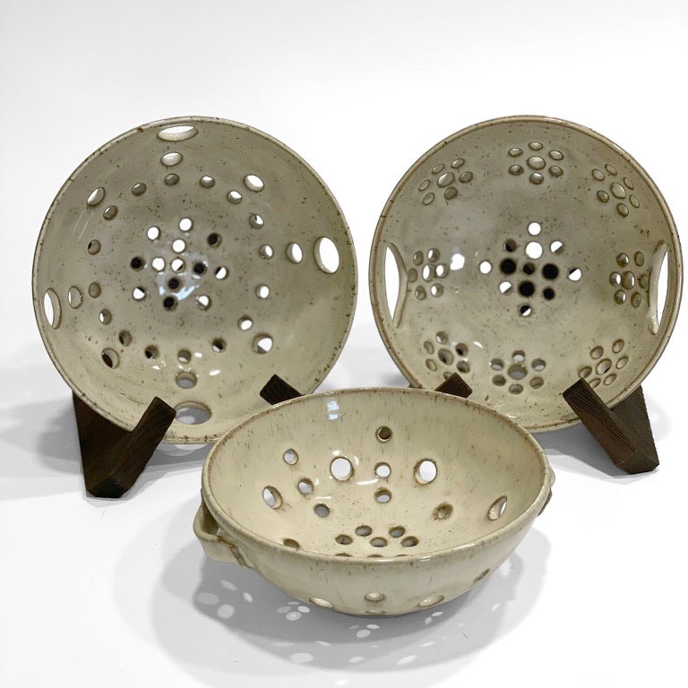 Three speckled cream berry bowls with patterned holes