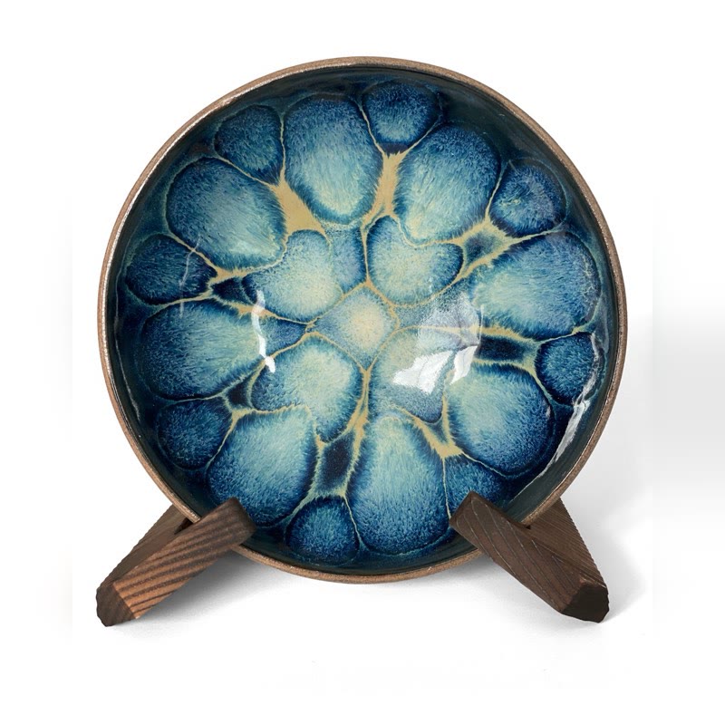 Bowl on a stand with deep blue glaze blooms edged in cream