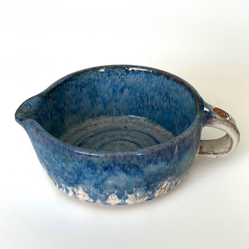 Blue glazed pouring jug with a carved dot band and white handle
