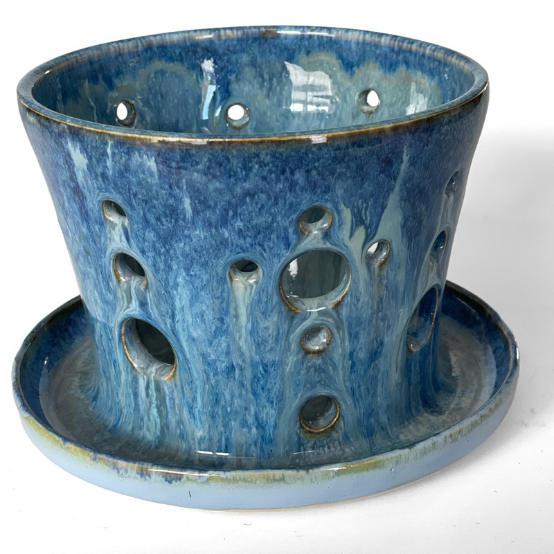 Blue drip-glazed planter with pierced holes and a saucer