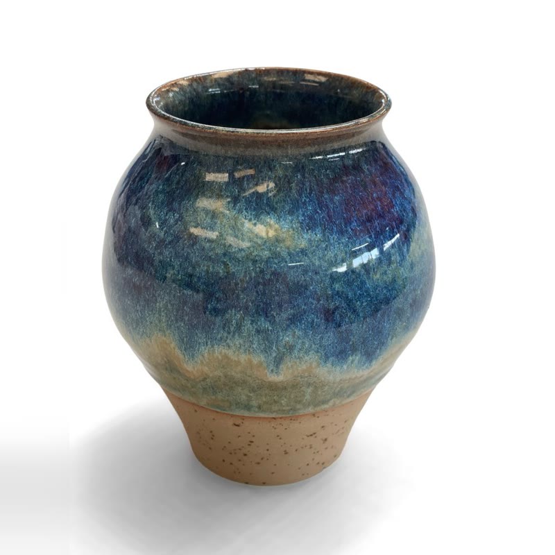 Small rounded vase in blue and violet glaze over a bare clay foot
