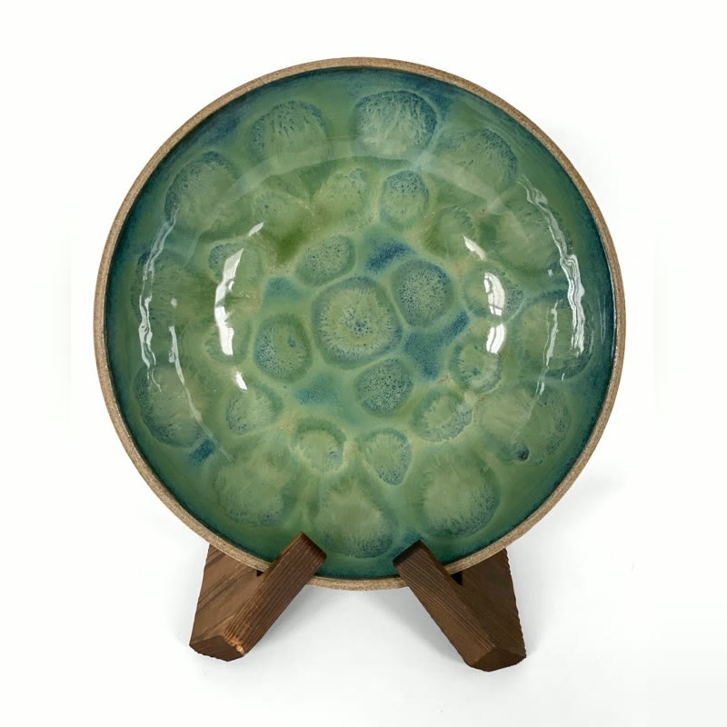 Green and blue bowl on a stand with soft glaze blooms