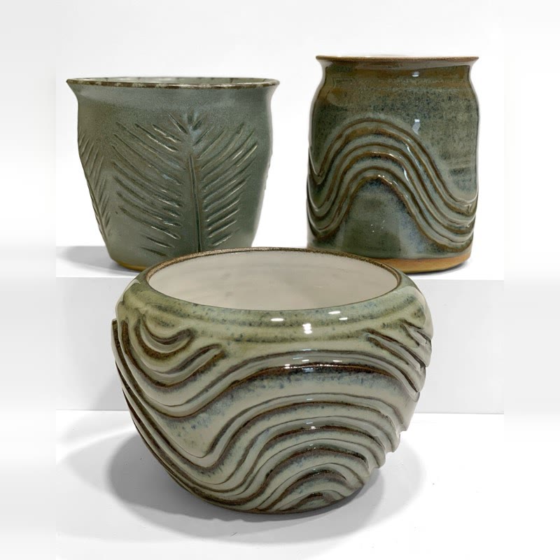 Carved green vessels and a wave bowl grouped together