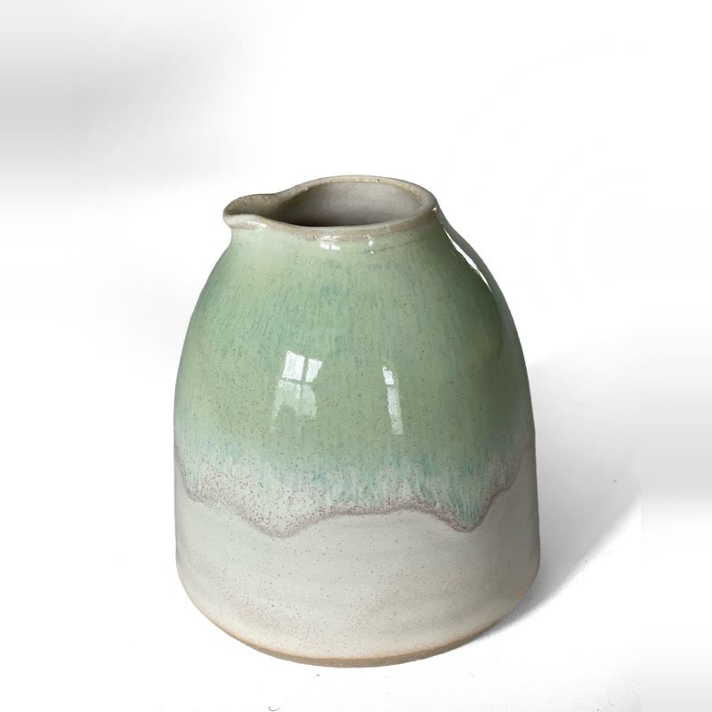 Small jug in pale green glaze dripping over white