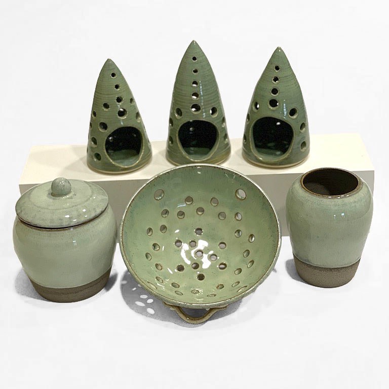 Green luminaries above a matching jar, berry bowl and vase