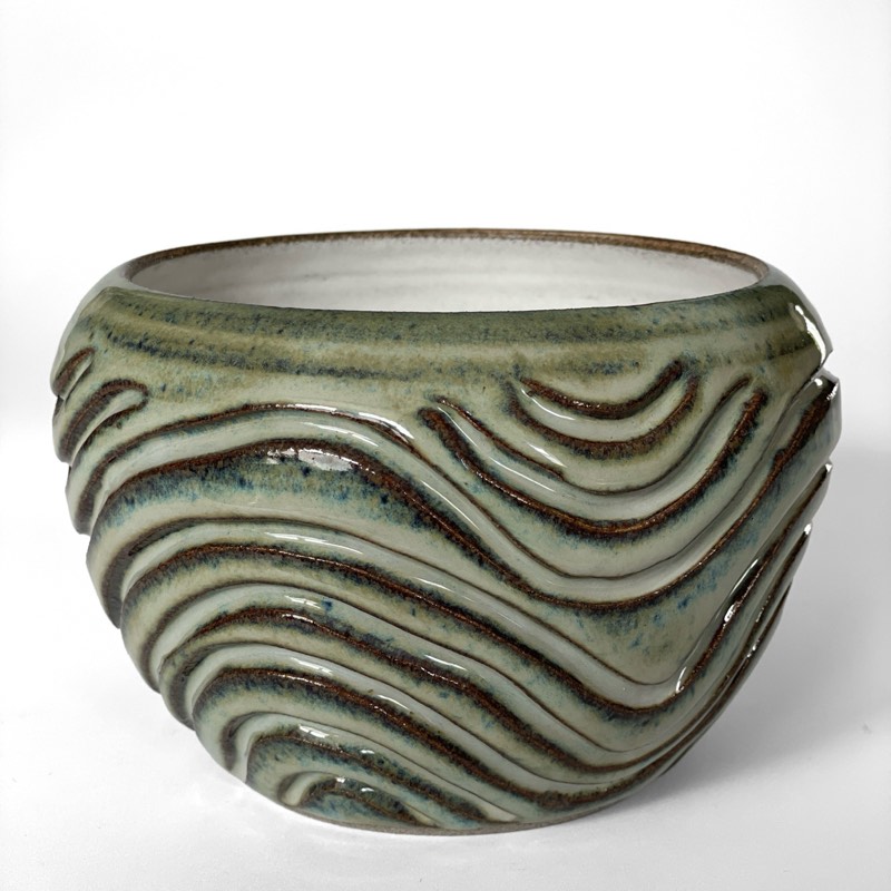 Round bowl in mossy green glaze carved with flowing waves