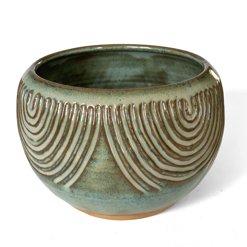 Carved sage-green stoneware bowl with rows of concentric arches