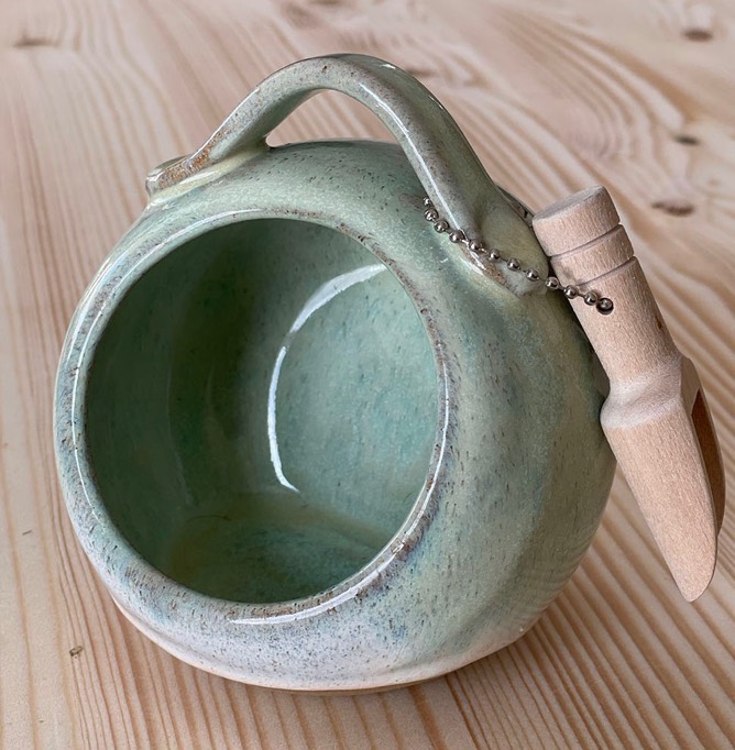Round sage green salt pig with a handle and a little wooden spoon