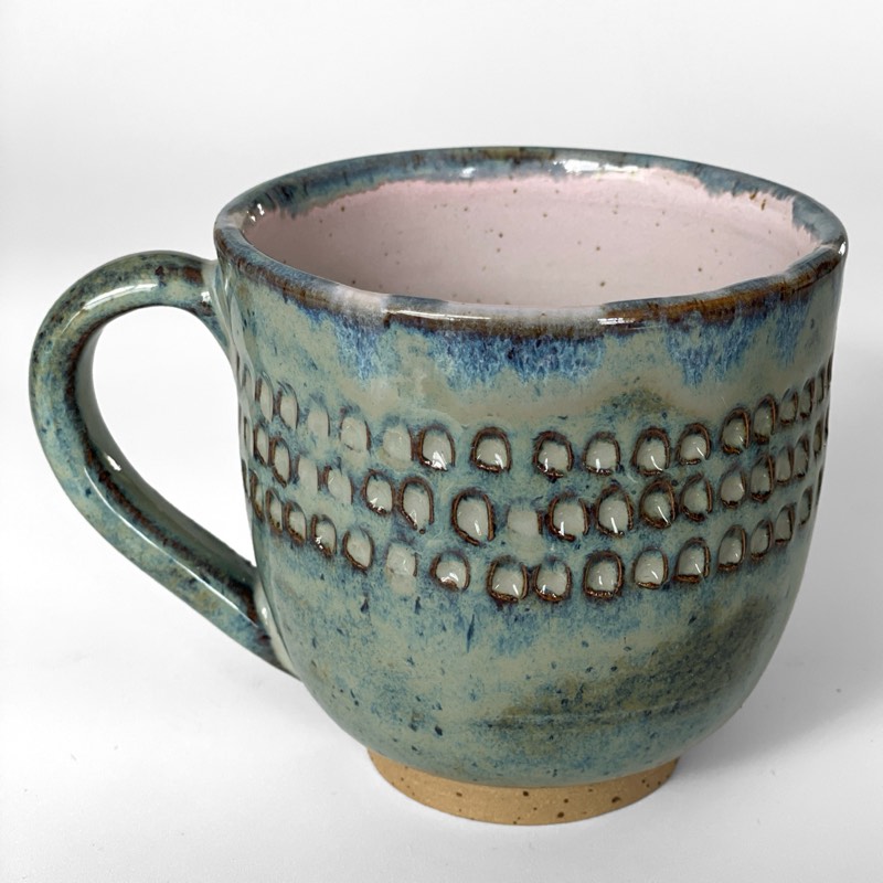 Sea green speckled mug with carved dots and a blush pink interior