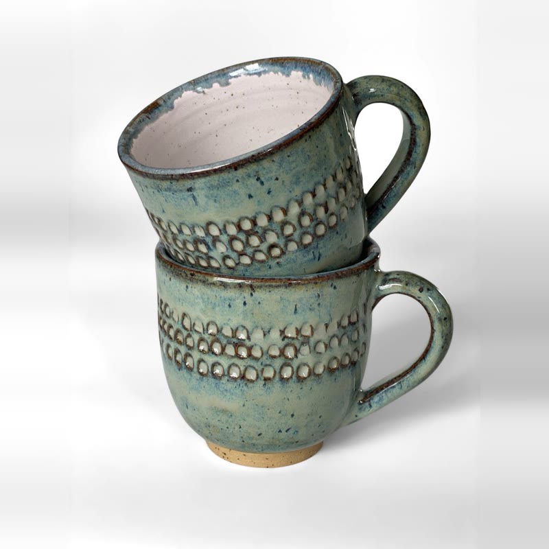 Two sea green carved mugs stacked