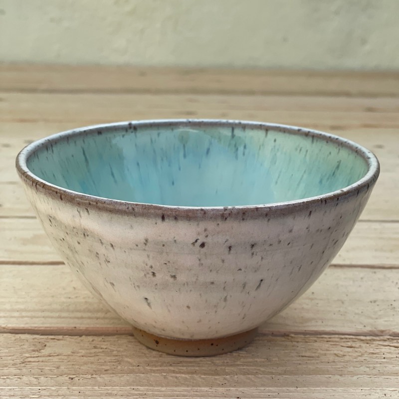 Speckled cream bowl with a bright aqua glaze inside