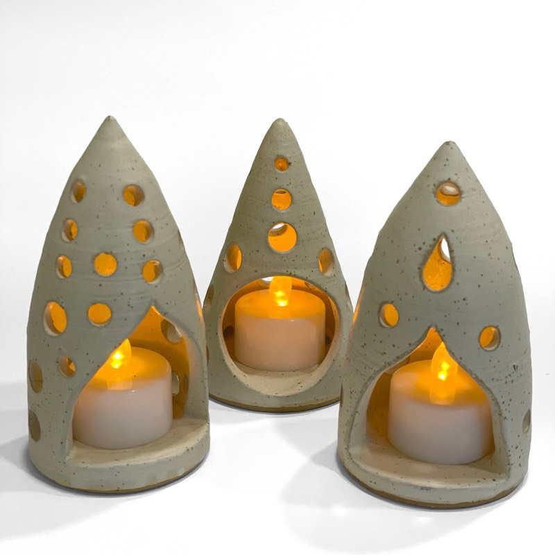 Three speckled cream pointed luminaries with glowing tealights